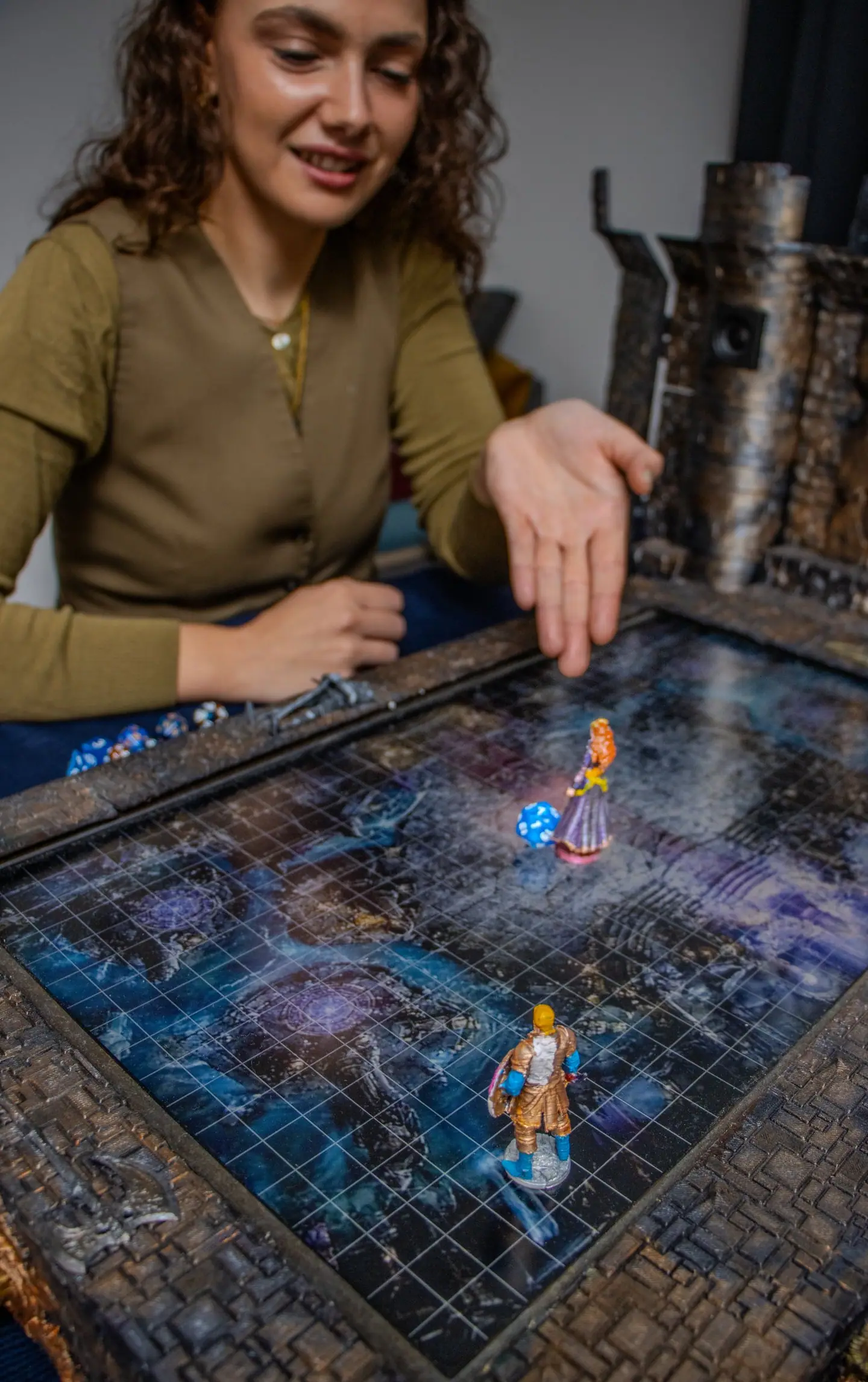Eine Person lächelt am Doungim Kartenbrett, das eine blaue Karte mit Miniaturen zeigt