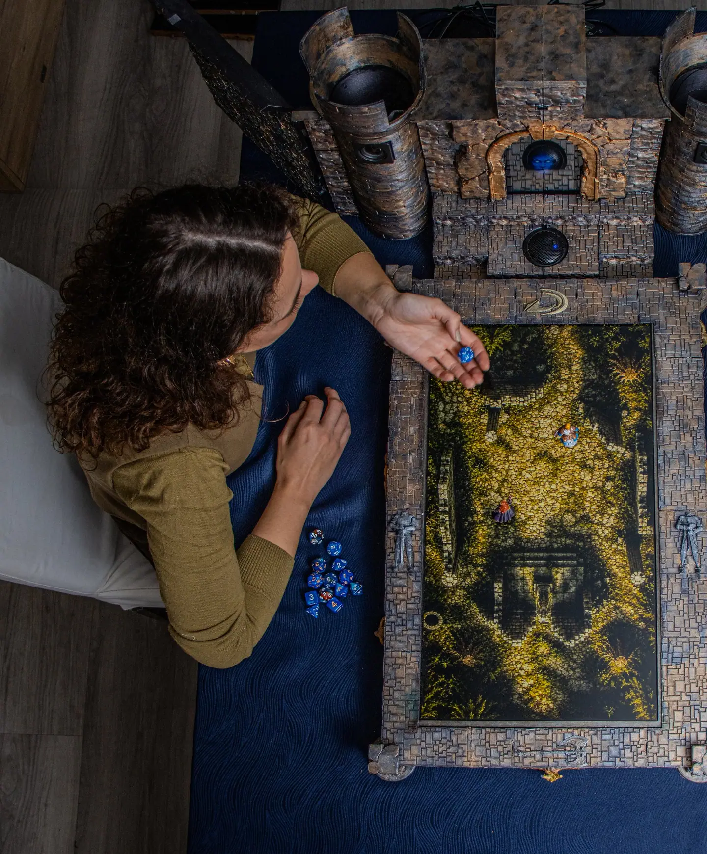 View from above of a player at the Doungim console, with a gold map on the board and dice beside it