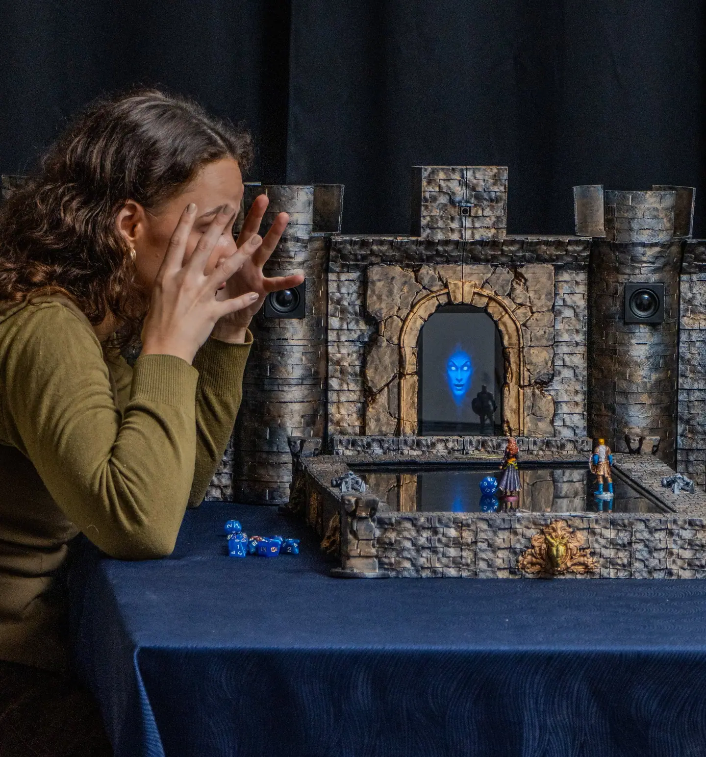 A player reacts to a moment in the game with both hands raised to the face, beside the Doungim console