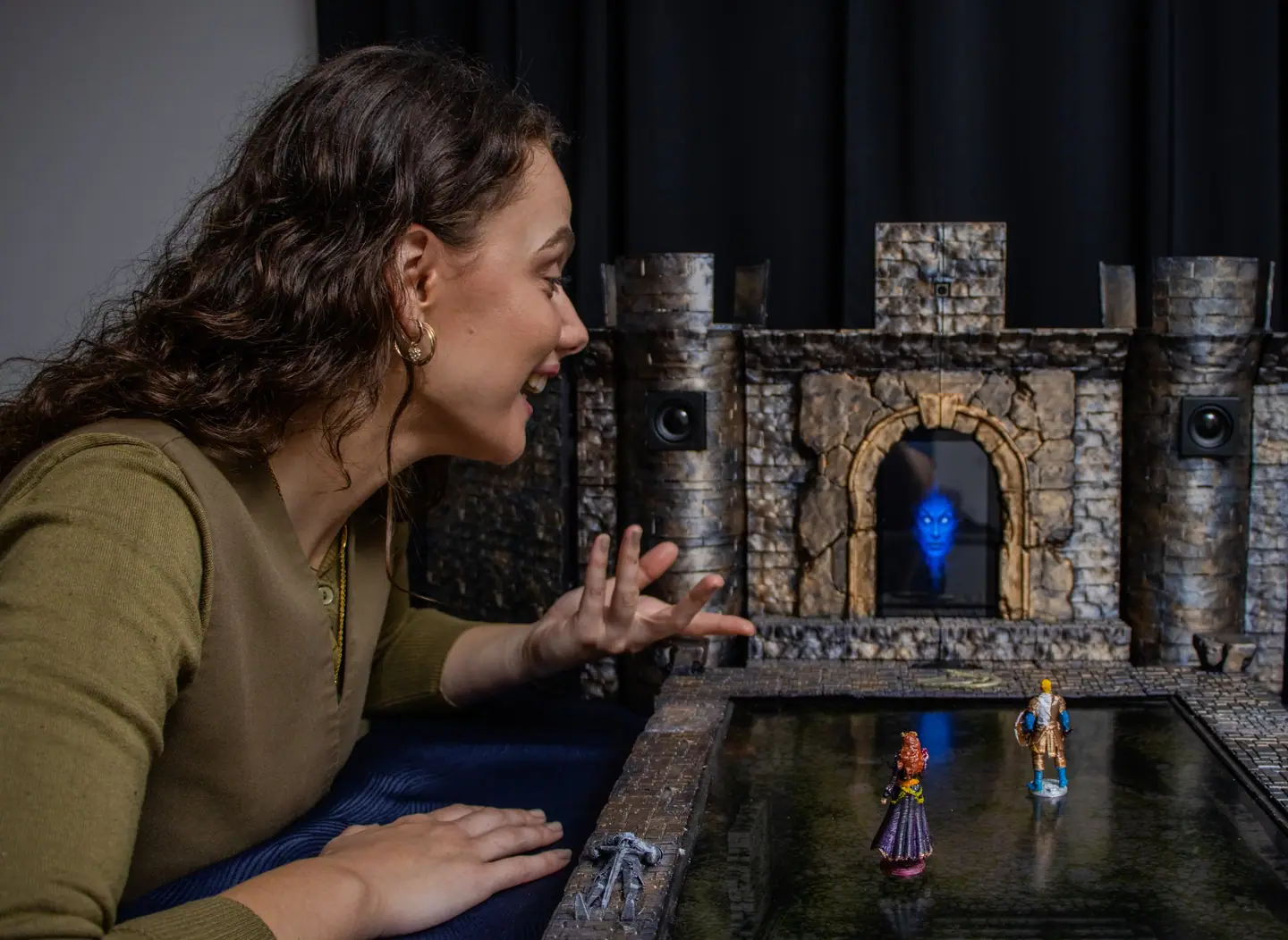 A player leans in and reacts during a game, with the Doungim gate unit and map board behind
